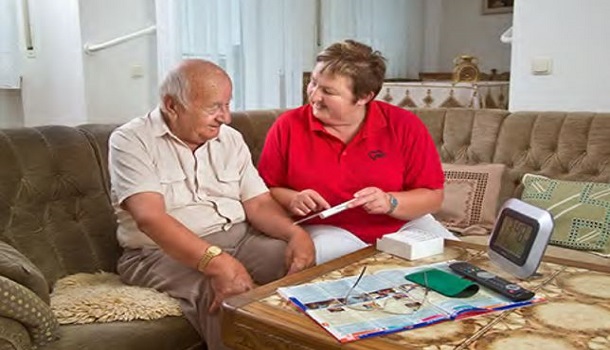 Das Bild zeigt eine Mitarbeiterin mit einem Patienten in einem Beratungsgespräch